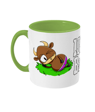 Load image into Gallery viewer, A brown bull with big horns reclining on a patch of grass wearing pink briefs.
