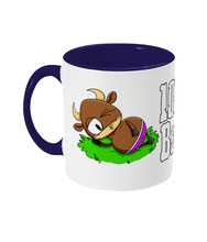 Load image into Gallery viewer, A brown bull with big horns reclining on a patch of grass wearing pink briefs.
