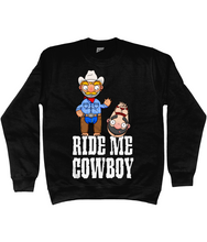 Load image into Gallery viewer, A gay cowboy wearing checked shirt, jeans, chaps and a cowboy hat standing next to a naked man hog tied with red rope.

