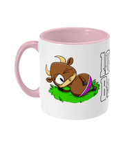 Load image into Gallery viewer, A brown bull with big horns reclining on a patch of grass wearing pink briefs.
